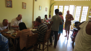 Stephen Knapp (Sri Nandanandana Prabhu) and other guests honor Krishna prasadam 